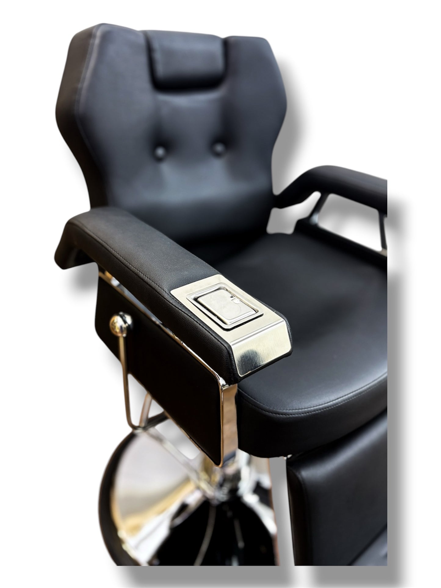 Black barber chair with chrome accents on a white background