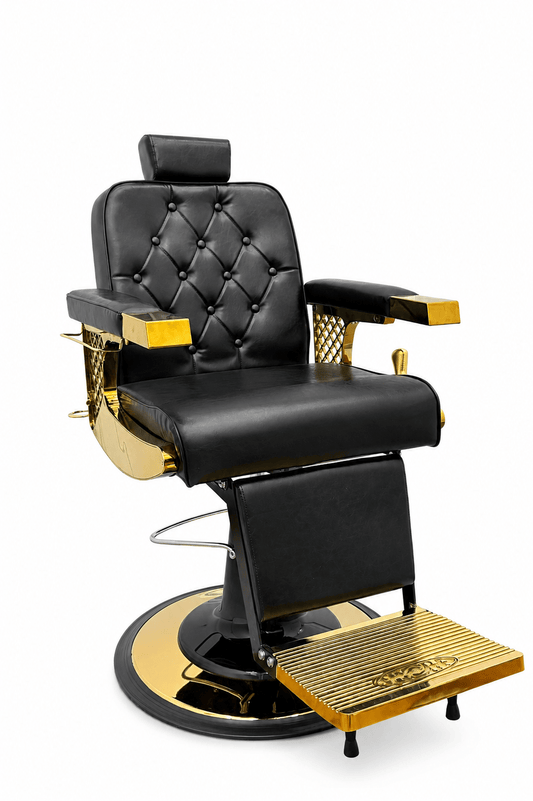 A luxury barber chair with black tufted leather upholstery and polished gold-finished metal accents, set against a solid white background.